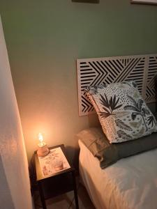 a bed with a table with a candle on it at Ostello di Lussello in Villadeati
