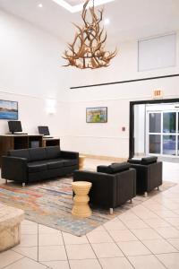 a living room with black furniture and a chandelier at La Quinta by Wyndham Kerrville in Kerrville