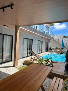 a house with a swimming pool and a wooden table at Pousada Bella Flor in Baía Formosa