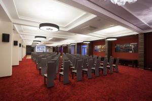 a room with rows of chairs on a red carpet at Hotel Soray in Wieliczka