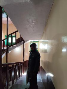 a man standing in a hallway of a building at Hill-Ten in Namche +3 photos