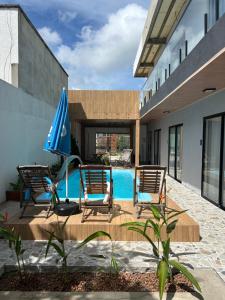 a patio with chairs and an umbrella and a pool at Pousada Bella Flor in Baía Formosa
