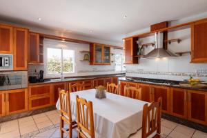 a kitchen with wooden cabinets and a white table with chairs at New! Villa Lina in Santa Gertrudis de Fruitera +28 photos