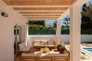 a patio with a table and chairs next to a pool at New! Villa Lina in Santa Gertrudis de Fruitera