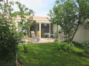 a backyard with a patio with a table and chairs at piedameretnature in Lagord +1 photo