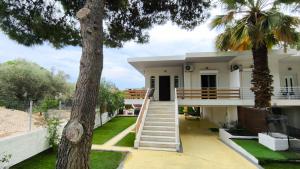 a house with a staircase and a palm tree at House with a pool, 2' from the beach in Kineta