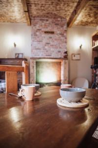 a wooden table with two cups and a fireplace at La Baguette du Sorcier - Logement insolite immersif jusque 4 personnes entre Liège & Maastricht in Visé +11 photos