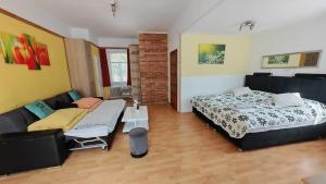 a living room with a bed and a couch at Haus Elena am Semmering in Steinhaus am Semmering