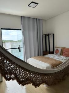 a bedroom with a hammock bed in front of a window at Pousada Bella Flor in Baía Formosa +91 photos