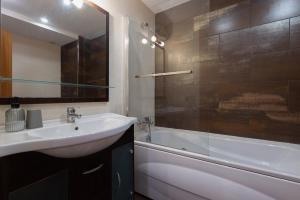 a bathroom with a sink and a shower and a tub at Les nid doré suites in Roses