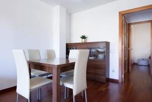 a dining room with a table and white chairs at Les nid doré suites in Roses +5 photos