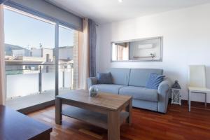 a living room with a couch and a table at Les nid doré suites in Roses