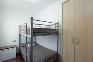 a metal bunk bed in a room with a closet at Les nid doré suites in Roses