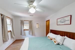 a bedroom with a bed with a ceiling fan at Worries not Found in Kill Devil Hills