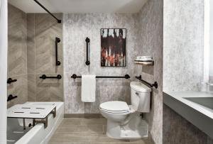 a bathroom with a toilet and a tub and a sink at Renaissance Mobile Riverview Plaza Hotel in Mobile