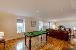 a living room with a pool table and a couch at Ballo Cottage - Stunning views in Leslie