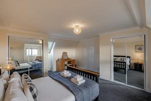 a bedroom with a large bed with a mirror at Ballo Cottage - Stunning views in Leslie