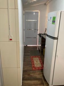 a kitchen with a white refrigerator and a hallway at Suíte rural in Foz do Iguaçu