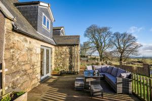 a patio with a blue couch on a wooden deck at Ballo Cottage - Stunning views in Leslie