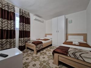 a hotel room with two beds and a bathroom at Adriatic Villa Matea in Budva