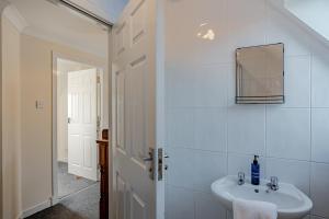 a white bathroom with a sink and a mirror at Ballo Cottage - Stunning views in Leslie +62 photos