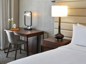 a hotel room with a bed and a desk with a lamp at Renaissance Mobile Riverview Plaza Hotel in Mobile