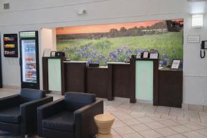 a waiting room with a painting of a field of flowers at La Quinta by Wyndham Kerrville in Kerrville