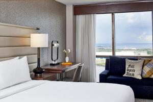 a hotel room with a bed and a desk and a chair at Renaissance Mobile Riverview Plaza Hotel in Mobile +160 photos