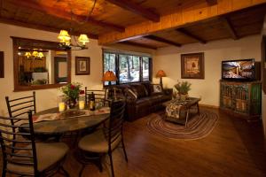 een woonkamer met een tafel en een bank bij Cottam's Lodge by Alpine Village Suites in Taos Ski Valley