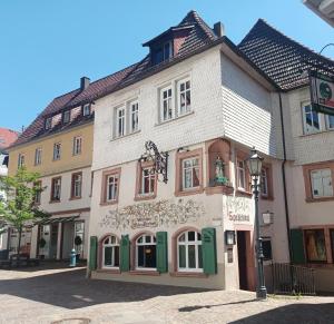 a large white building with green trim on a street at Appartement Neckartal in Hirschhorn