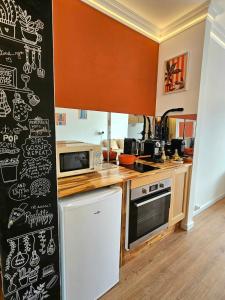 a kitchen with a chalkboard wall with drawings on it at Studio cosy - Porte de Genève & Voie Verte in Ambilly
