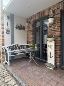 a patio with a table and a bench next to a building at Gode Wind in Eckernförde