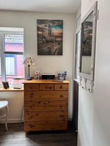 a bedroom with a wooden dresser and a desk at Gode Wind in Eckernförde