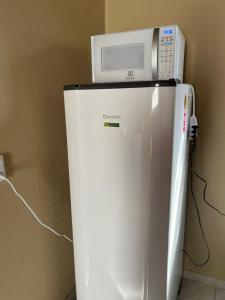 a microwave sitting on top of a refrigerator at Casa Tito in Cascavel