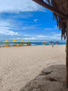 a beach with umbrellas and people on the beach at Casa Tito in Cascavel