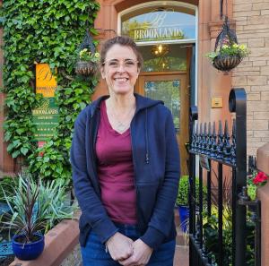 a woman standing in front of a building at Brooklands 5 Star Guest House in Penrith