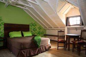 a bedroom with a bed with green walls and a table at casaJOMO in Rio de Janeiro +89 photos