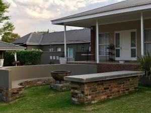 a home with a stone bench in the yard at Anathi Hotel in Kokstad +3 photos