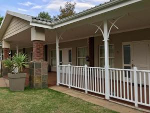 a house with a white fence and a porch at Anathi Hotel in Kokstad