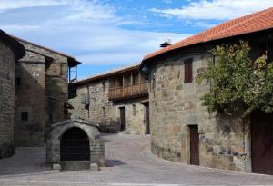 an old stone building with a doorway in a courtyard at Hotel Lupus Silva in Villardeciervos