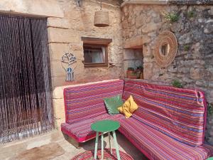 a red couch sitting next to a stone building at Gîte de Bontemps in Saint-Vincent-de-Cosse