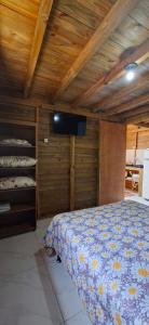 a bedroom with a bed in a room with wooden ceilings at Pousada PortoBello Praia do Rosa in Imbituba