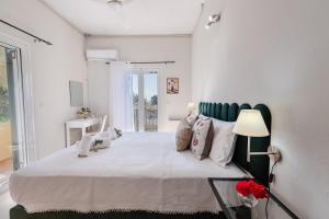 a white bedroom with a large bed and a lamp at The 7 Trees Apartments by Konnect, Nisaki in Nisaki +19 photos