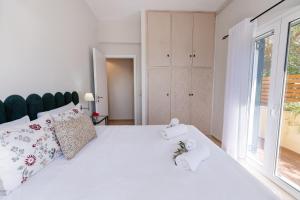 a bedroom with a large white bed with towels on it at The 7 Trees Apartments by Konnect, Nisaki in Nisaki