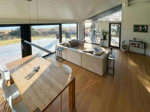 a living room with a couch and a table and chairs at Idyllic Modern House Overlooking Lammefjord in Vig