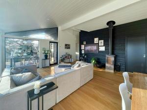 a living room with a couch and a fireplace at Idyllic Modern House Overlooking Lammefjord in Vig +17 photos