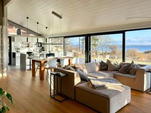 a living room with a couch and a table and some windows at Idyllic Modern House Overlooking Lammefjord in Vig