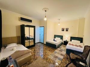 a hotel room with two beds and a mirror at Monument Pyramids View in Cairo +15 photos