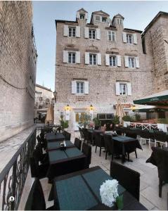 a restaurant with tables and chairs in front of a building at XII Century Heritage Hotel in Trogir