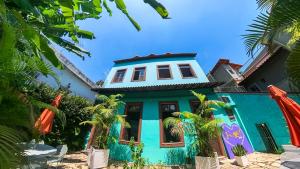 a blue house with palm trees in front of it at casaJOMO in Rio de Janeiro